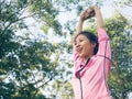 Asian young woman warm up the body stretching before morning exercise and yoga in the park under warm light morning.