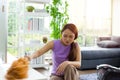 Asian woman is dusting the television shelf