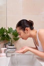 Asian young woman washing her face on the sink Royalty Free Stock Photo