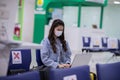 Asian young woman wearing face maks holding passport and boarding pass at airport Due Covid-19 flu virus pandemic