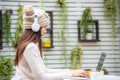 Asian young woman wearing sweater, sitting and working laptop with hot coffee, smart phone at home garden in winter season, weeken Royalty Free Stock Photo