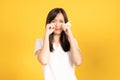 Asian young woman wearing white t-shirt standing and holding a tissue paper using her face wiping tears Royalty Free Stock Photo