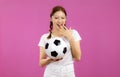 Asian Young woman in white t-shirt over isolated pink background holding a soccer ball Royalty Free Stock Photo