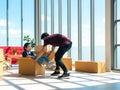 Asian young woman who sitting in brown parcel box pretend worker man uncomfortable packing stuff for relocation and move to the Royalty Free Stock Photo