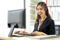 Asian young woman working in call centre. Young friendly operator woman agent with headsets working in a call centre Royalty Free Stock Photo