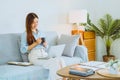 Asian young woman working from home using computer and drinking coffee in her room document finance and conference online meeting Royalty Free Stock Photo