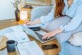 Asian young woman working from home using computer and drinking coffee in her room document finance and conference online meeting Royalty Free Stock Photo