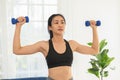 Asian young woman workout exercise with dumbbells to build bicep curl muscle.Arm day workout.Athlete woman concentration exercise Royalty Free Stock Photo