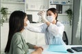 Asian young woman doctor using flashlight on patient`s eye in hospital. Attractive specialist physician wear mask, examining and Royalty Free Stock Photo