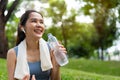 Asian young women drink water from a plastic bottle after exercises or sports. Asian woman running in garden. Beautiful fitness Royalty Free Stock Photo