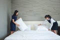 Asian young woman room maid making bed and pillow in hotel. Royalty Free Stock Photo