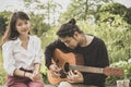 Asian younger man and woman playing guitar with happiness emotion Royalty Free Stock Photo