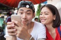 asian younger man and woman watching on smart phone use for people and digital technology ,wifi and internet connection Royalty Free Stock Photo