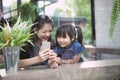 Asian younger woman and children looking to smart phone screen at home living room Royalty Free Stock Photo