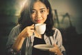 Asian younger woman  drinking hot coffee in white cup Royalty Free Stock Photo