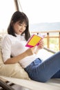 Asian younger woman ralaxing reading a book Royalty Free Stock Photo