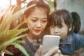 Asian younger woman and children looking to smart phone screen a