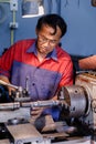 Asians Craftsman being machined steel in a factory