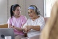 Asianwoman teach older mother, how to wash hand with alcohol from online learn in living room with carefully. family Royalty Free Stock Photo