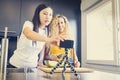 Asiatic girl and caucasian girl making a video for a blog with fruit in the kitchen