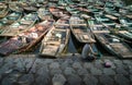 Asiatic Woman handwashes laundry in the amazing harbor with wooden boats moored. A unique scene of typical Vietnamese life