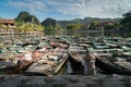 Asiatic Woman handwashes laundry in the amazing harbor with wooden boats moored. A unique scene of typical Vietnamese life