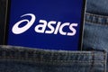 Asics logo displayed on smartphone hidden in jeans pocket