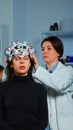 Asistance of neurological doctor putting eeg headset on patient head