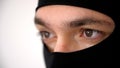 Close-up portrait of a man in a black balaclava. Brown eyes close up. Thief or burglar angry. Royalty Free Stock Photo