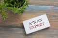 Ask an expert. Business card with message. Office supplies on desk table top view.