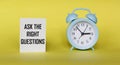 ASK THE RIGHT QUESTIONS - words on a yellow background with a clock. Information concept Royalty Free Stock Photo