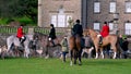 Tight shot of horse riding fox hunt officials and other members of the field with English Foxhounds gathered in front of