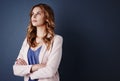 Asking herself the tough questions. Studio shot of an attractive young businesswoman looking thoughtful against a dark Royalty Free Stock Photo