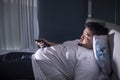 Asleep obese man in bedroom during watches TV Royalty Free Stock Photo