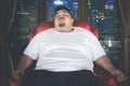 Asleep obese man on the sofa at night Royalty Free Stock Photo