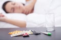 Asleep unhealthy woman and pills on the nightstand