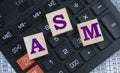 ASM - acronym on wooden cubes on the background of a calculator Royalty Free Stock Photo
