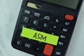 ASM and Calculator write on sticky notes isolated on Wooden Table Royalty Free Stock Photo