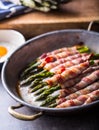 Asparagus. Asparagus and roll bacon. Grilled asparagus with rolled bacon and fried egg. Fried old pan full of rolled bacon with Royalty Free Stock Photo