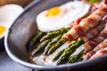 Asparagus. Asparagus and roll bacon. Grilled asparagus with rolled bacon and fried egg. Fried old pan full of rolled bacon with Royalty Free Stock Photo