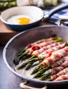 Asparagus. Asparagus and roll bacon. Grilled asparagus with rolled bacon and fried egg. Fried old pan full of rolled bacon with Royalty Free Stock Photo