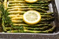 Asparagus baked with sliced lemon, fresh rosemary, butter, and cheese. Fresh baked delicious meal close up, just from the oven