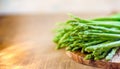 Asparagus, a bunch of fresh asparagus, on a wooden cutting board made of olive wood Royalty Free Stock Photo