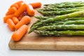 Asparagus and Carrots Close Up on a Wooden Chopping Board Royalty Free Stock Photo