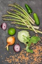 Asparagus, cucumbers, lime and kohlrabi, onions and red lentils on table