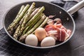 Asparagus eggs bacon and garlic in ceramic pan Royalty Free Stock Photo