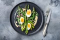 Asparagus with eggs and french dressing with dijon mustard, onion chopped in red vinegar  taragon on grey textured background, top Royalty Free Stock Photo