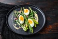 Asparagus with eggs and french dressing with dijon mustard, onion chopped in red vinegar  taragon on old dark wooden table, side Royalty Free Stock Photo