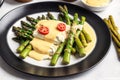 Asparagus with hollandaise sauce on a white plate, closeup. Healthy food concept. Generative AI