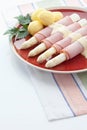 Asparagus,potatoes,ham and parsley in plate on white background